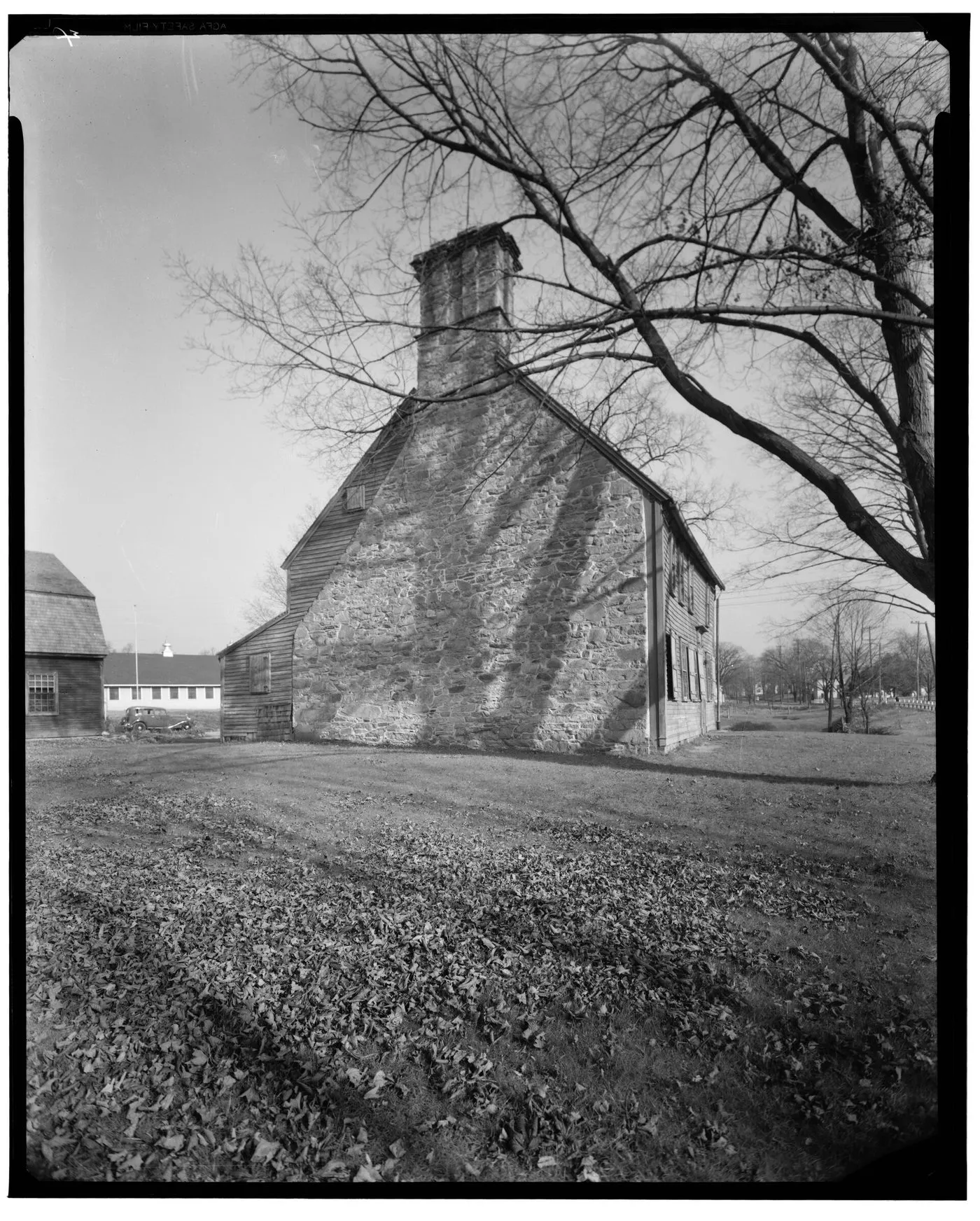 A timber-framed colonial house behind bare trees, photographed in 1937.